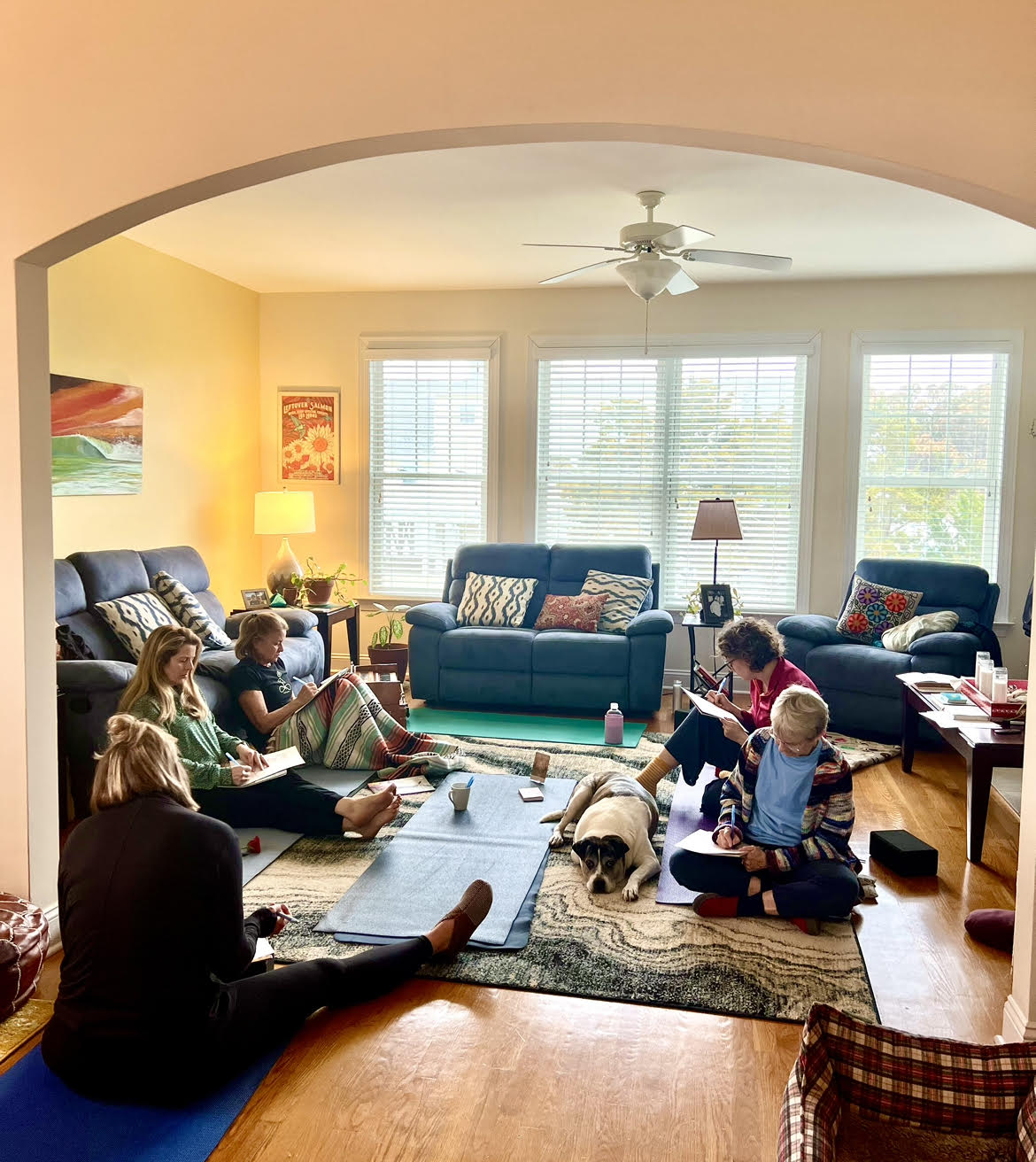 Group of women journaling together in a warm living room gathering